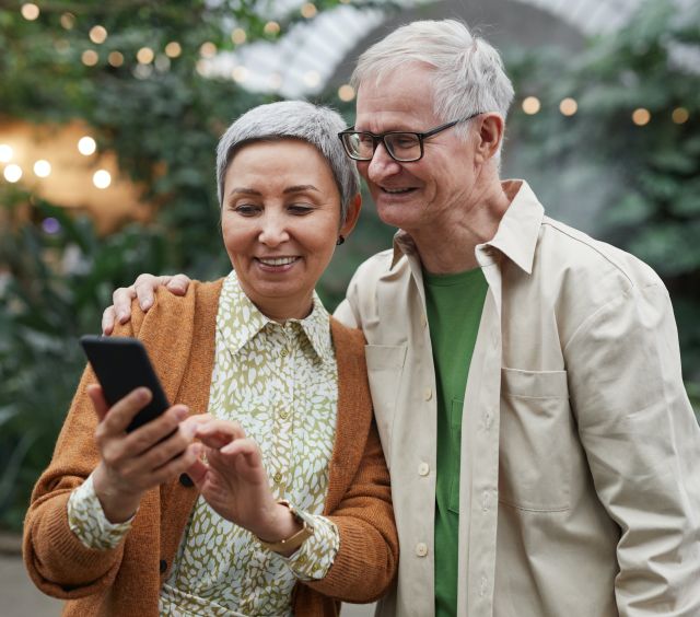 Couple Smiling While Looking at a Smartphone